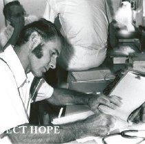 Dr writing orders at the Nursing station